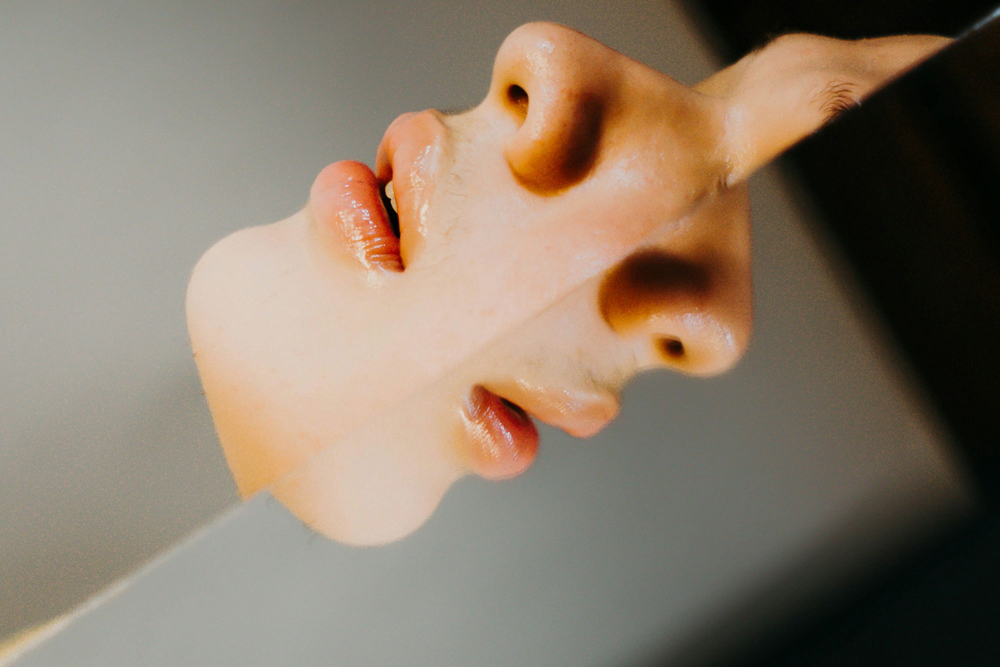 A woman's face is reflected in a mirror